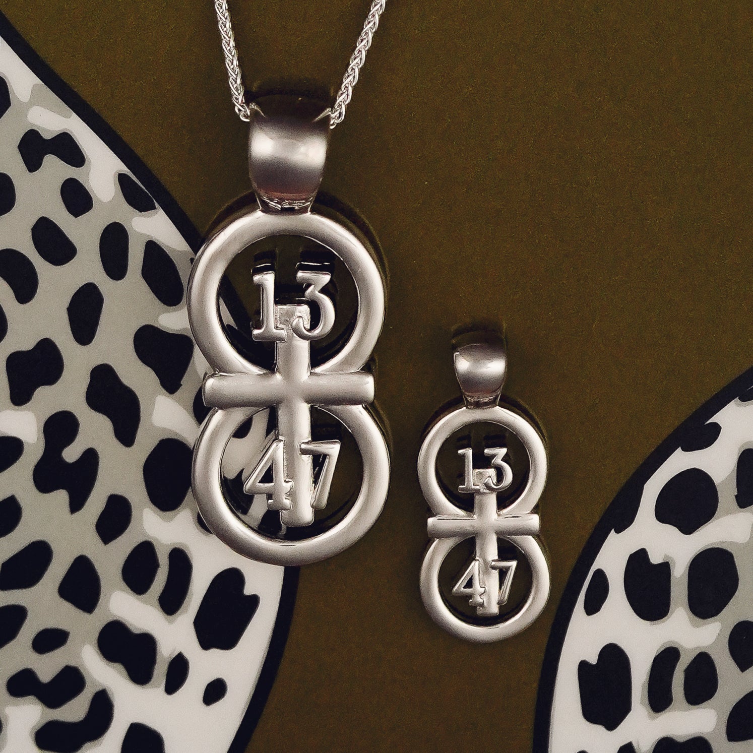 The silver RIYAN 29 and 11® pendant has the numbers 13, 4, and 4 intertwined with the cross to represent 1 Corinthians 13:4-7 with the chapter word "1 Corinthians" inscribed on the back.