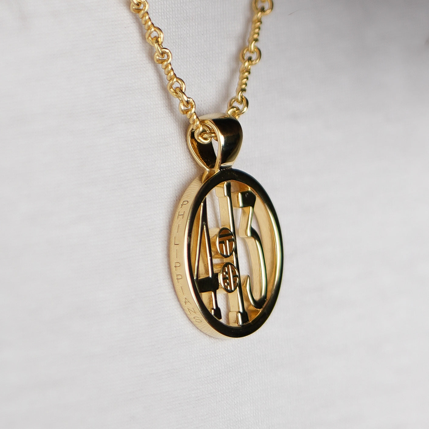 The Ashe is our monogram pendant inspired by our beloved monograms that grace all the thing we love and use daily. The numbers 4 and 13 are stretched vertically to the edges of the pendant. The numbers 4 and 13 are separated by a colon which is represented by our logo. Down the vertical side of the pendant the chapter name 'Philippians' is inscribed on the monogram pendant.