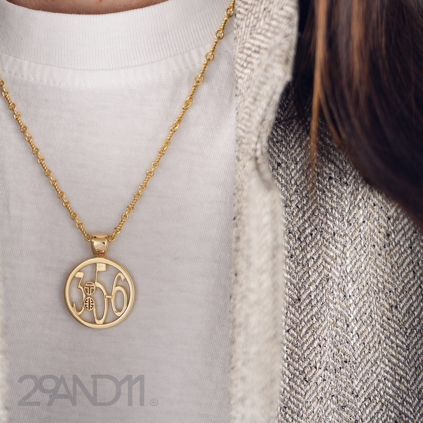 The Ashe is our monogram pendant inspired by our beloved monograms that grace all the thing we love and use daily. The numbers 3, 5, and 6 are stretched vertically to the edges of the pendant. The numbers 3, 5, and 6 are separated by a colon which is represented by our logo.Down the vertical side of the pendant the chapter name Proverbs is inscribed on the monogram pendant.  Model is wearing the pendant on a 18" Rolo chain with a white t-shirt and houndstooth blazer.