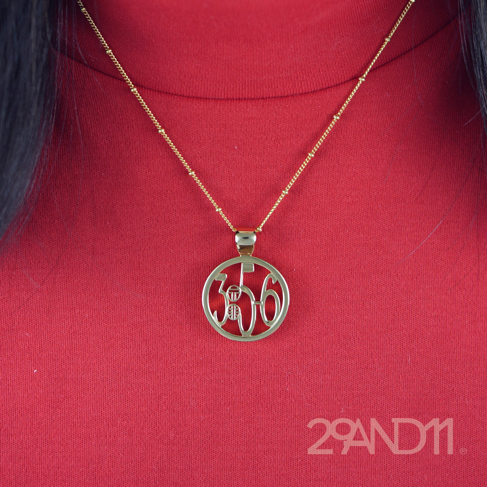 The Ashe is our monogram pendant inspired by our beloved monograms that grace all the thing we love and use daily. The numbers 3, 5, and 6 are stretched vertically to the edges of the pendant. The numbers 3, 5, and 6 are separated by a colon which is represented by our logo.Down the vertical side of the pendant the chapter name Proverbs is inscribed on the monogram pendant.  Model is wearing the pendant on a 18" satellite chain and red high neck tank.