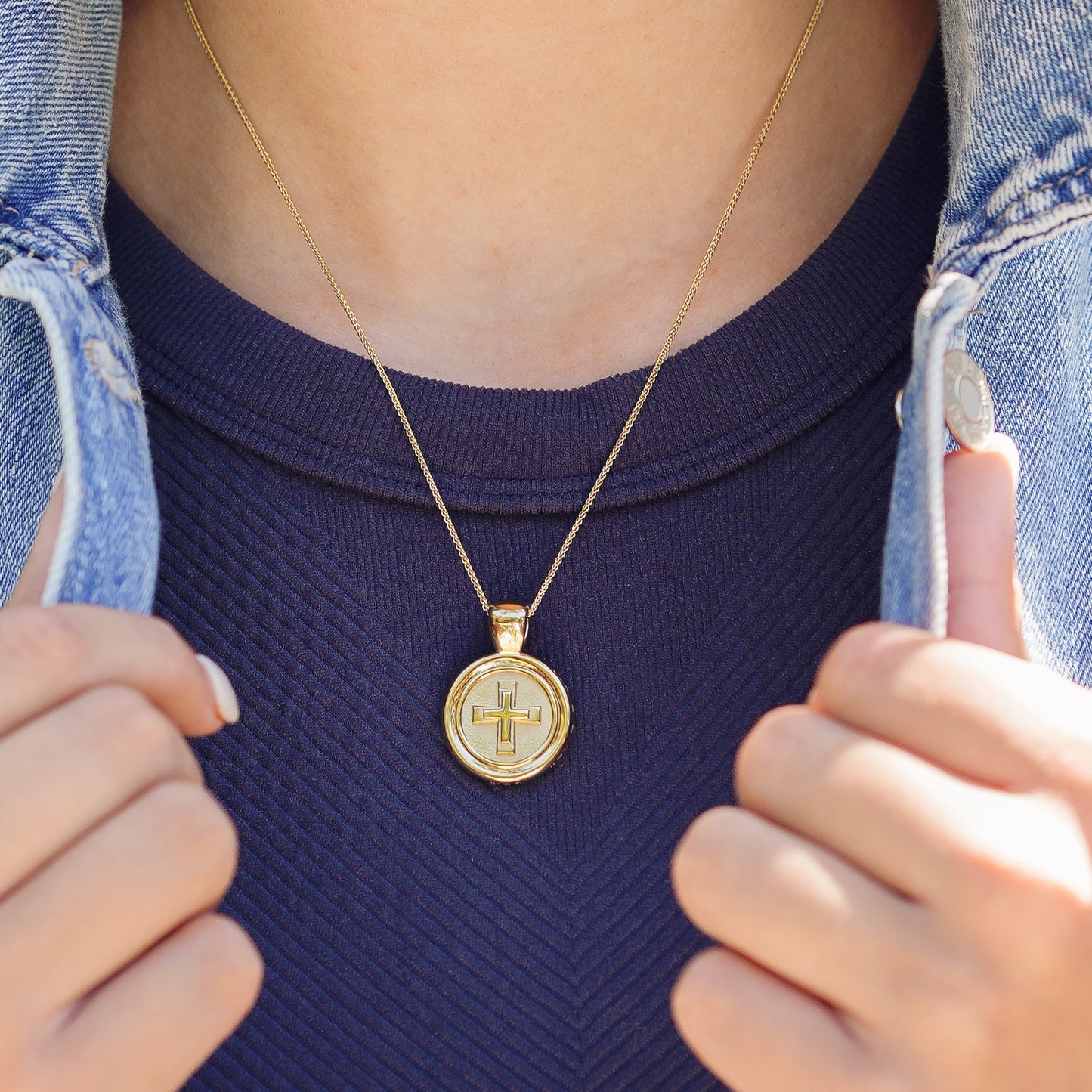 The WYIT is our first reversible pendant.&nbsp; One side of the medallion has the numbers 5 and 7 with our logo displayed as the colon between the chapter and verse.&nbsp; &nbsp;The other side of the pendant has a raised two tier cross. Down the vertical side of the pendant the chapter name 2 Corinthians is inscribed on the medallion.  Model is wearing the pendant on our 18" Wheat chain on the cross side.  Model is wearing a navy high neck tank & denim jacket.