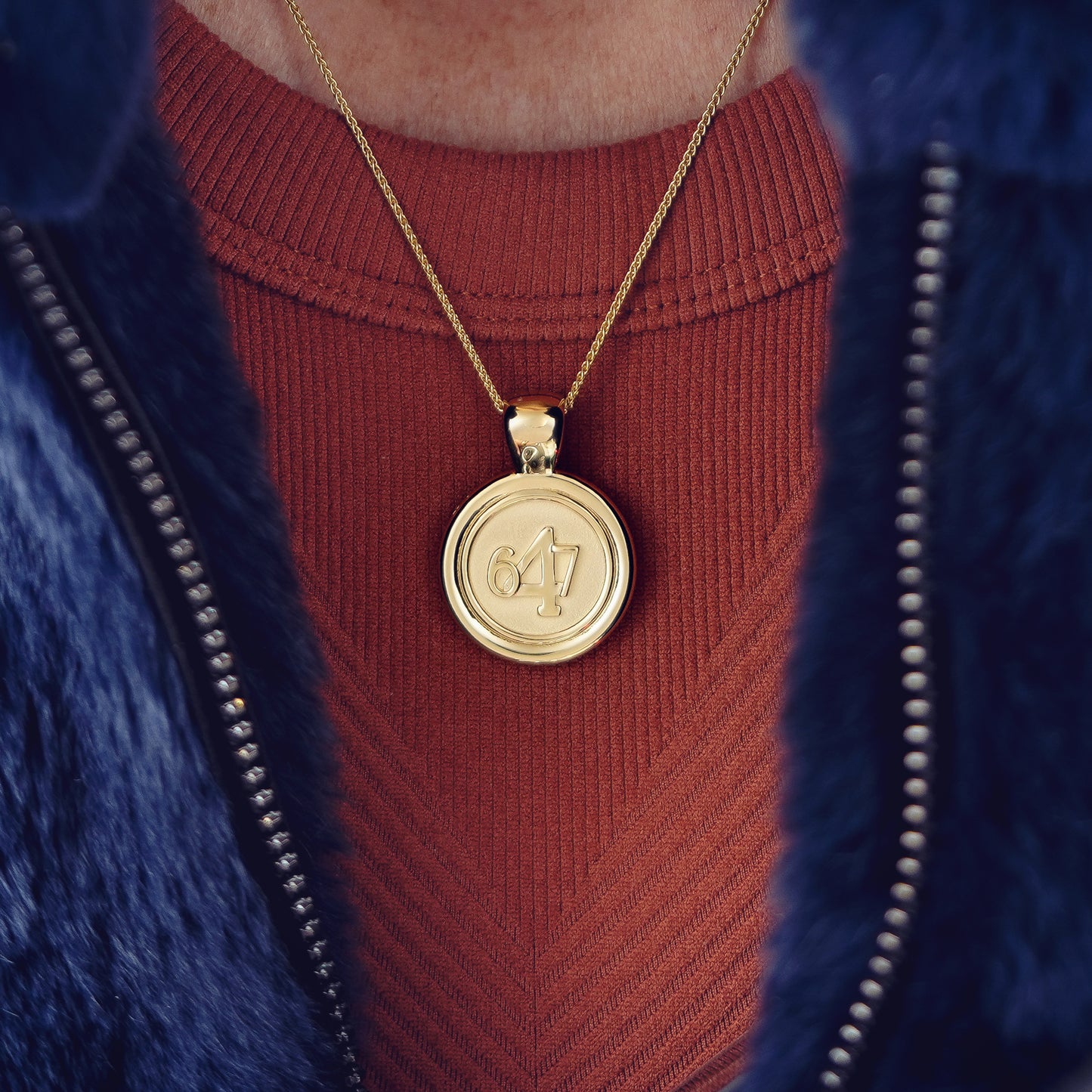 The WYIT is our first reversible pendant. One side of the medallion has the number 4 in the center of the pendant with the numbers 6 and 7 on each side.&nbsp; The other side of the pendant has a raised two tier cross. Down the vertical side of the pendant the chapter name Philippians is inscribed on the medallion.  Model is wearing a burnt red tank with a navy blue CB Furs jacket with WYIT pendant on an 18" wheat chain.