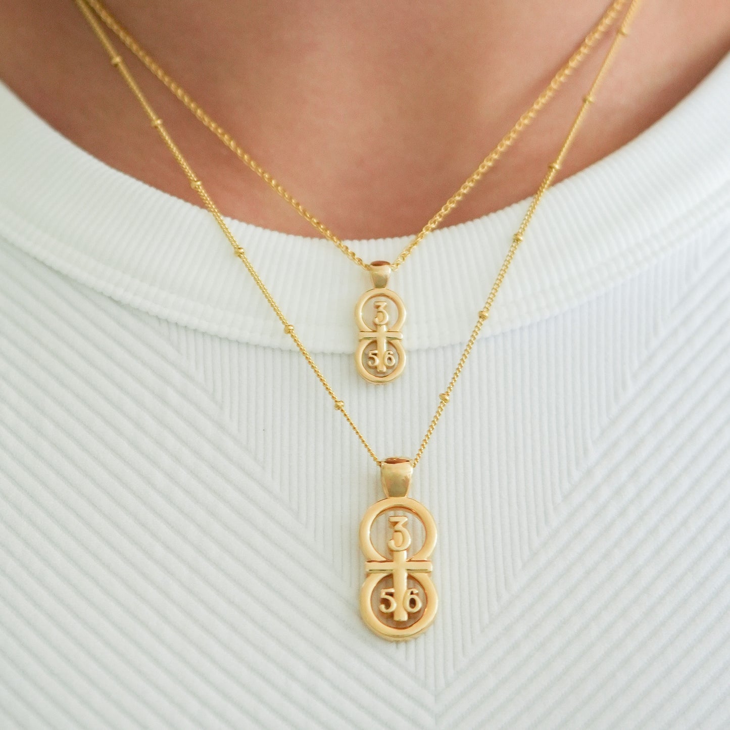 Gold small and large pendants displayed on the neck with this wheat chain and satellite chain on the larger pendant.  Our 29 and 11® pendant has the numbers 3, 5, and 6 intertwined with the cross to represent Proverbs 3:5-6 with the chapter word "Proverbs" inscribed on the back.