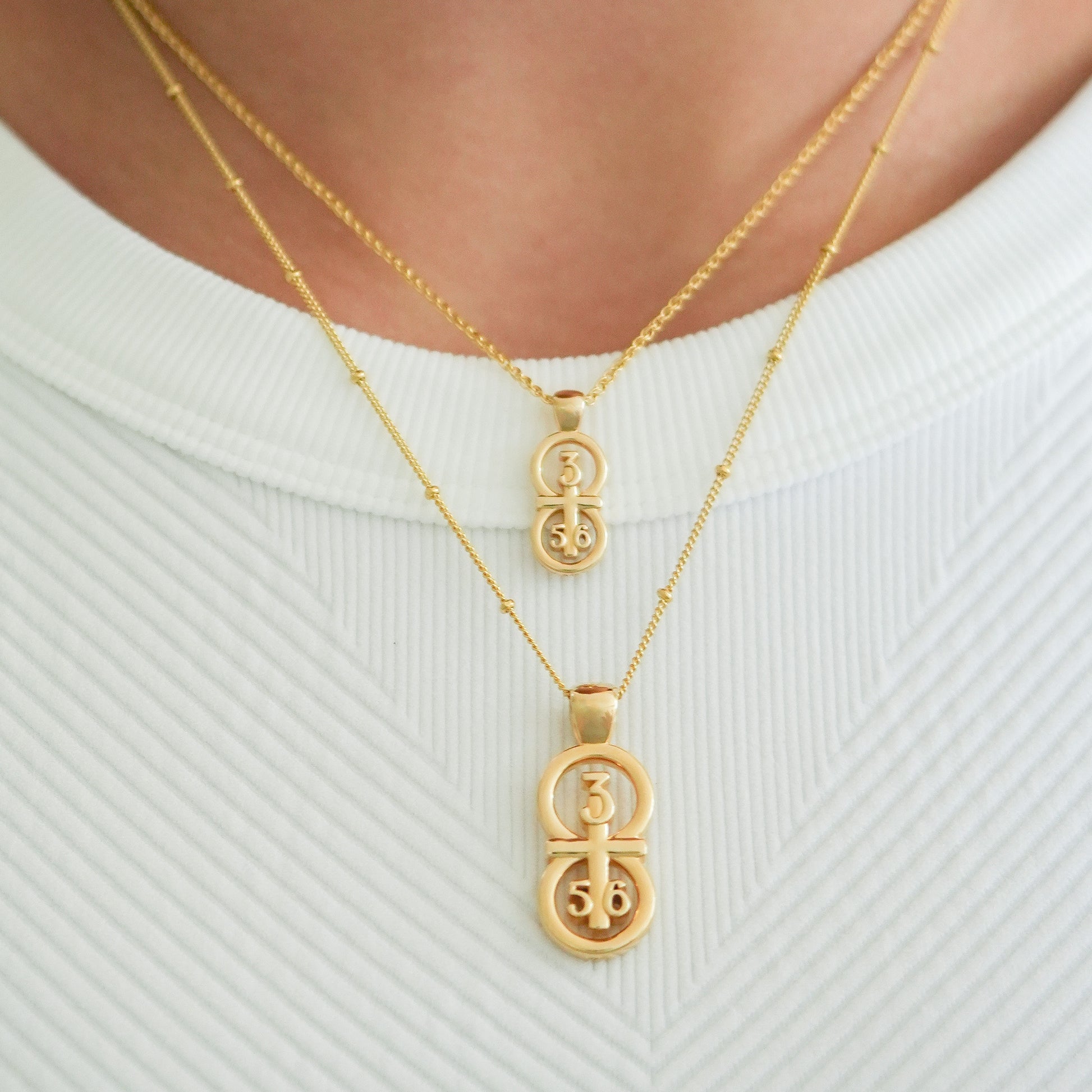 Gold small and large pendants displayed on the neck with this wheat chain and satellite chain on the larger pendant.  Our 29 and 11® pendant has the numbers 3, 5, and 6 intertwined with the cross to represent Proverbs 3:5-6 with the chapter word "Proverbs" inscribed on the back.