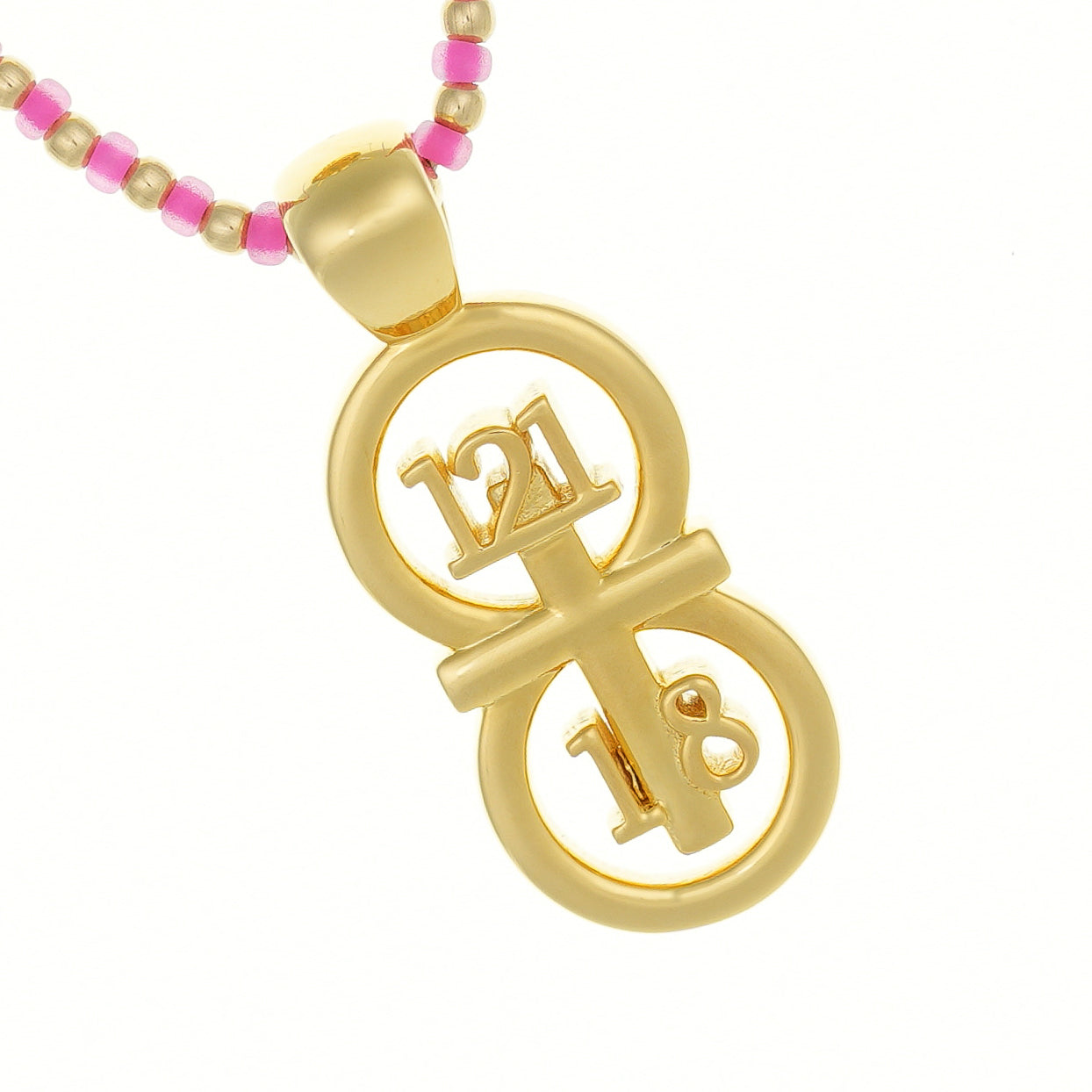 Gold small PSALM 121:1-8 pendant displayed on a white background with a pink custom hand beaded necklace. The RIYAN 29 and 11® pendant has the numbers 121, 1, and 8 intertwined with the cross to represent Psalm 121:1-8 with the chapter word "Psalm" inscribed on the back.